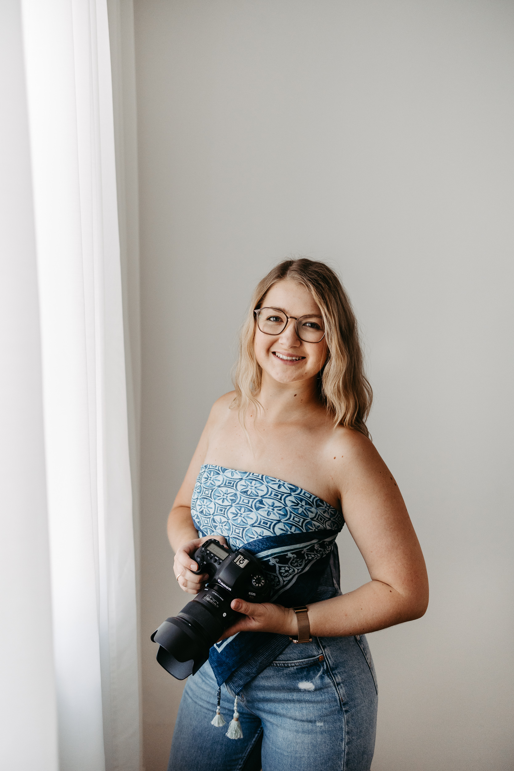Lachende Fotografin mit Kamera im Tageslichtstudio in Freistadt