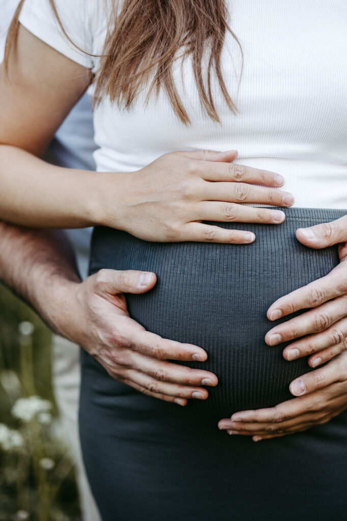 Detail: Hände auf dem Babybauch, andere Perspektive