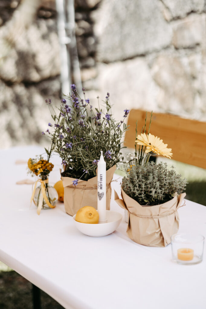 Tischdeko-Detail mit Lavendel, Zitronen und Kerze in Papiertüten-Töpfen
