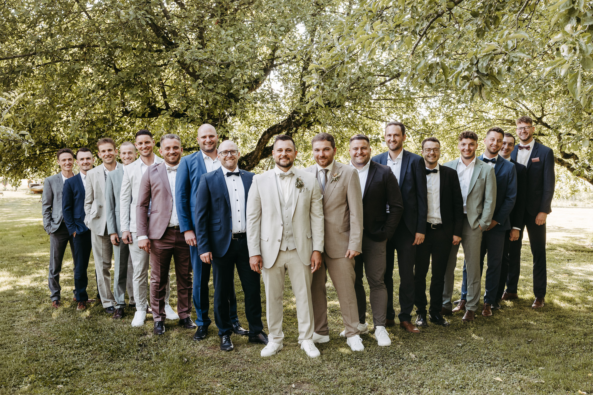 Gruppenfoto der Trauzeugen und männlichen Hochzeitsgäste im Obstgarten
