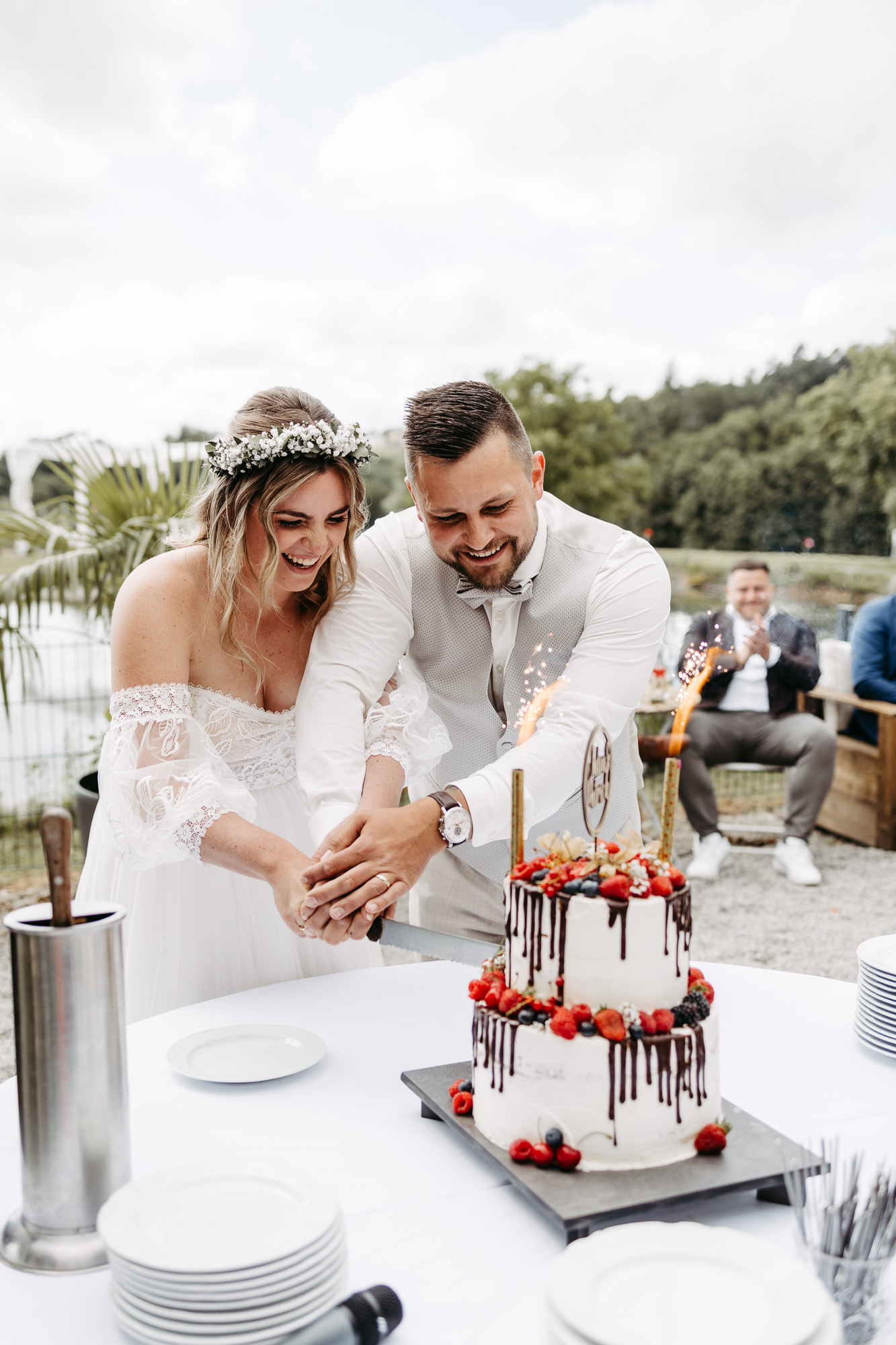 Brautpaar schneidet gemeinsam die Hochzeitstorte an, Wunderkerzen sprühen Funken
