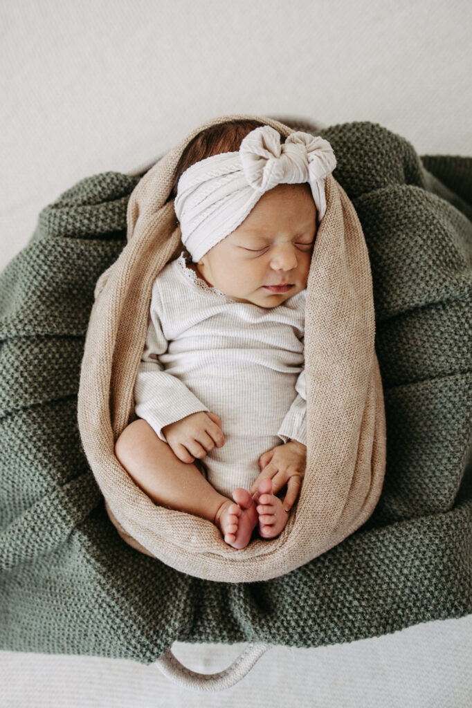 Baby eingewickelt in eine Decke, kleine Füßchen schauen heraus