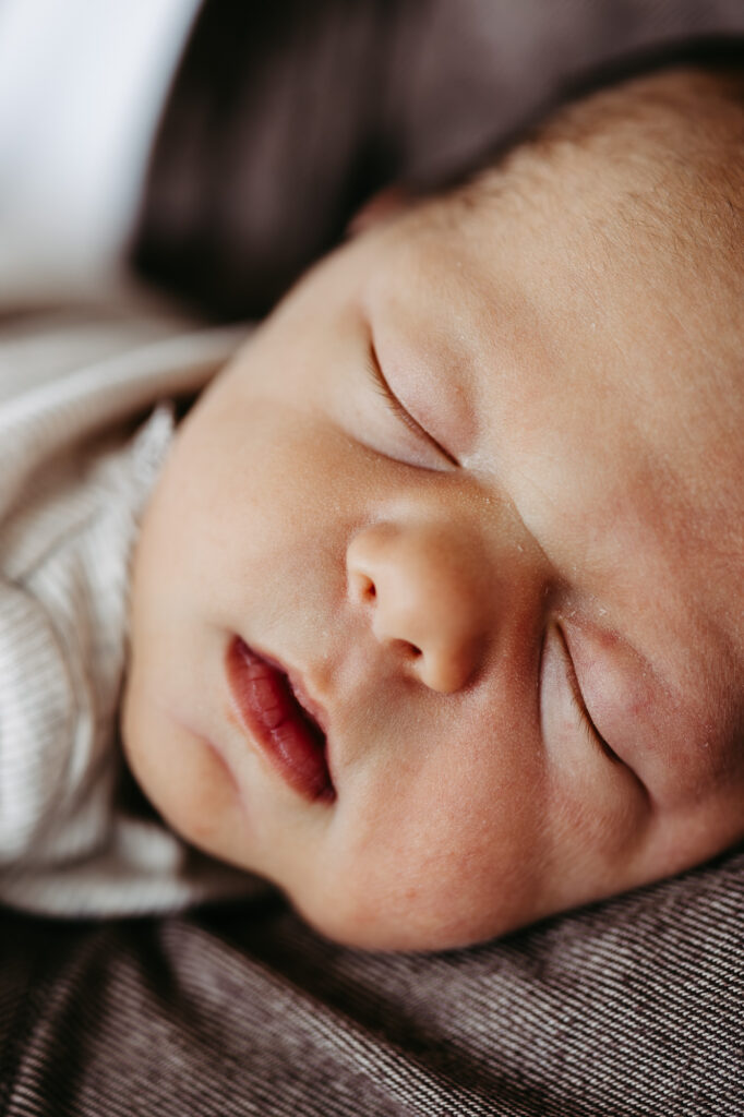 Nahaufnahme des schlafenden Babygesichts mit Wimpern und Grübchen