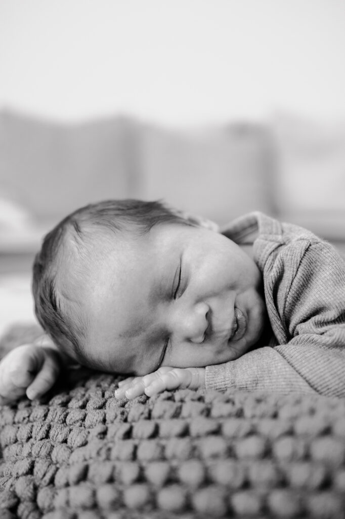 Baby schläft auf dem Strickkissen, Schwarz-Weiß