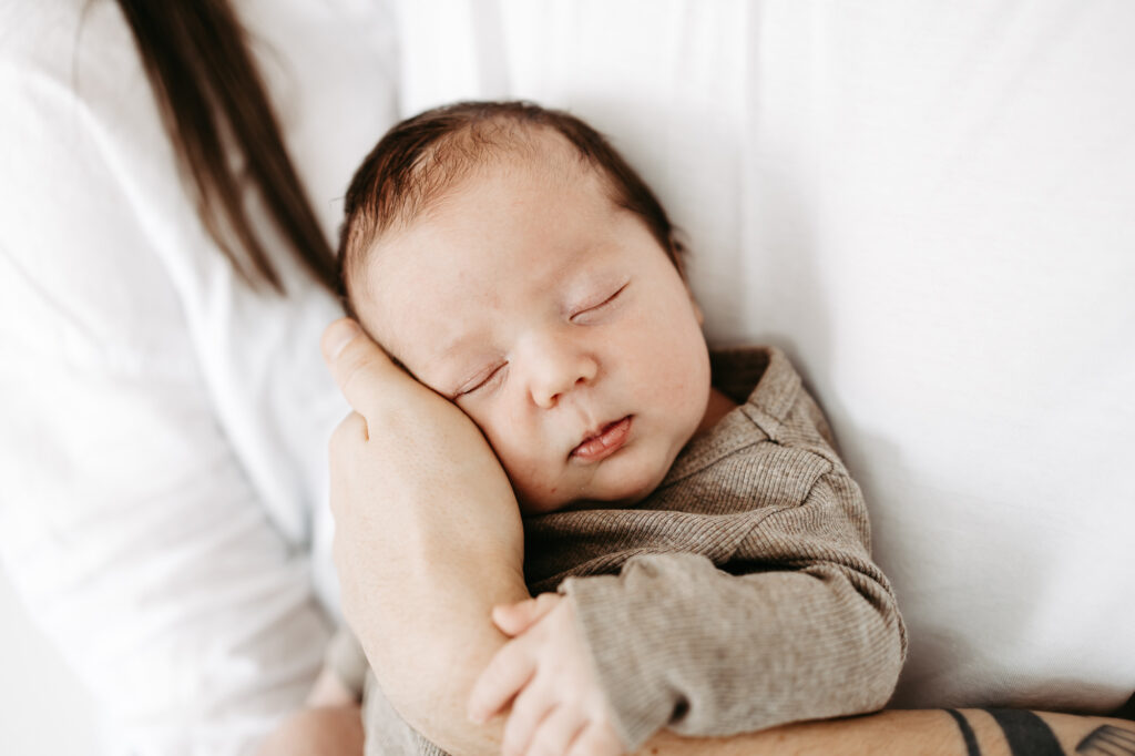 Nahaufnahme des schlafenden Babygesichts, Übergang zur gemütlichen Wohnzimmerkulisse