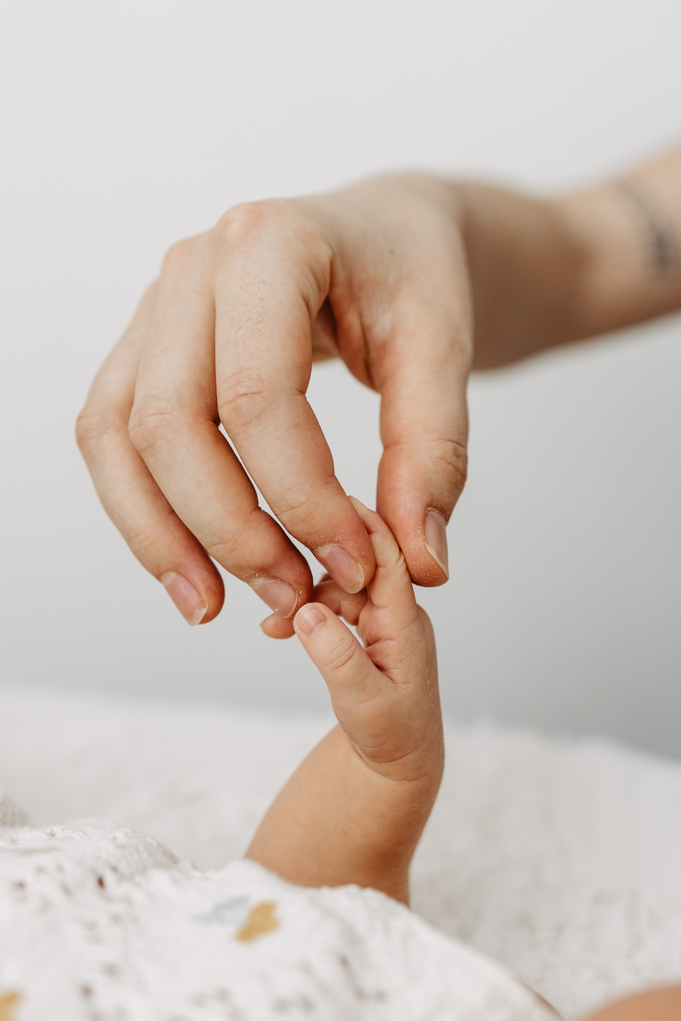 Nahaufnahme: das kleine Händchen des Babys hält den Finger der Mutter fest