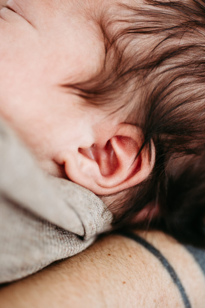 Familienportrait, Eltern lächeln in die Kamera, Baby schlafend gehalten, Schwarz-Weiß