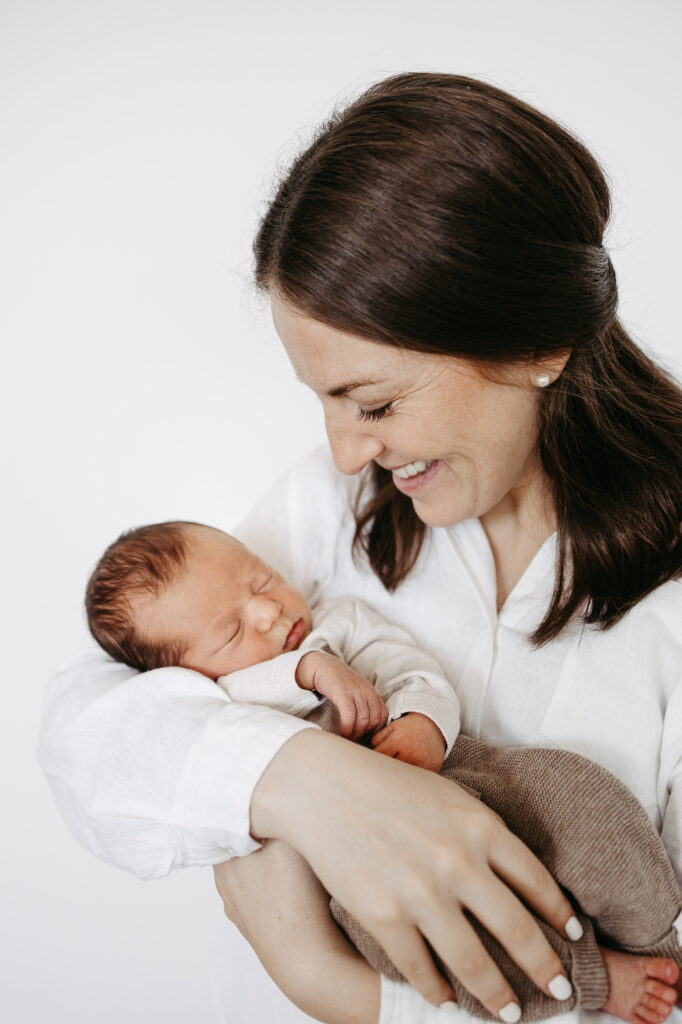 Mutter lächelt ihr Baby im Arm an