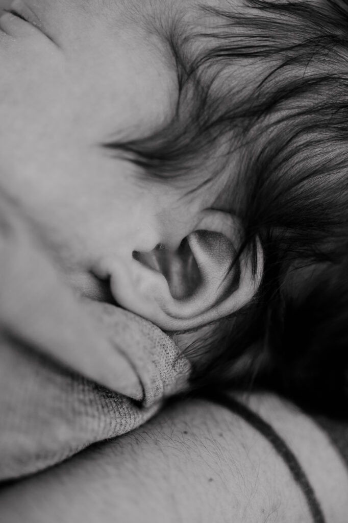 Nahaufnahme des Ohrs und der Haare des Babys, Schwarz-Weiß
