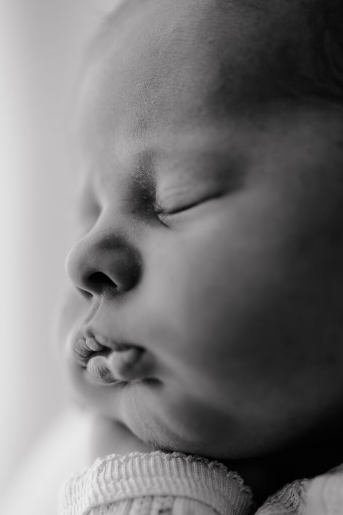 Vater hält sein Baby sanft in der Hand und lächelt es an
