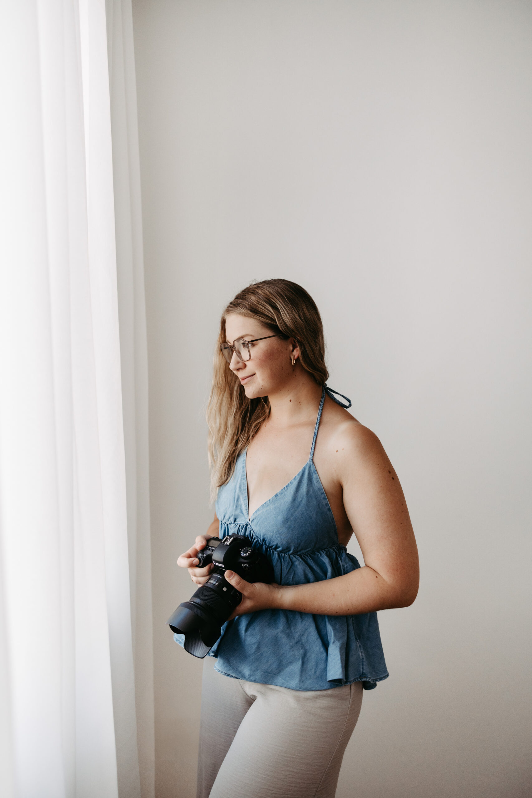 Sandra Dobusch, Fotografin, mit Kamera in der Hand, Blick zur Seite