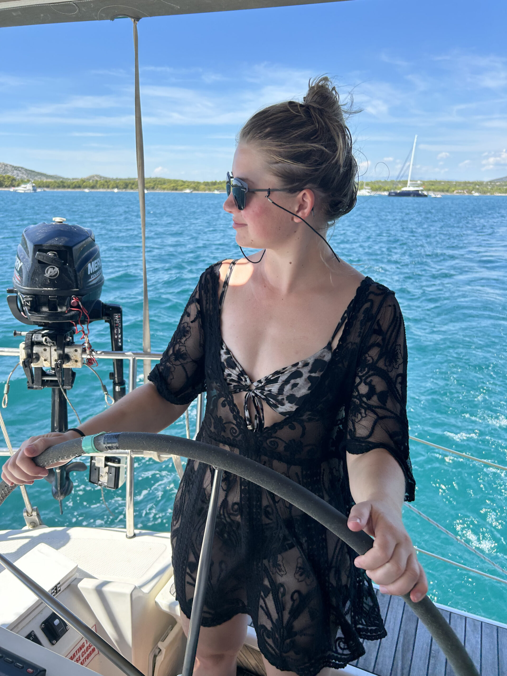 Sandra Dobusch am Steuerrad eines Segelboots, Blick aufs Meer